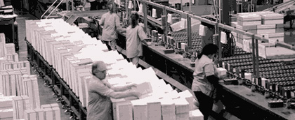 Photo of factory workers, part of a manufacturing system.