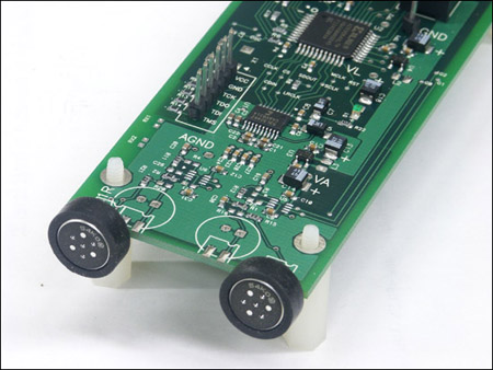 A mixed-signal printed circuit board containing both analog and digital components. The board is one component of a 1000-node acoustic beamformer being developed at MIT's Computer Science and Artificial Intelligence Laboratory. The board contains a pair of microphones, several resistors, capacitors, and digital integrated circuit chips.