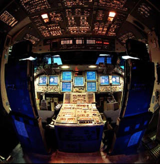 Photo of space shuttle cockpit showing computerized display panels.