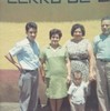 Two women, two men, and a small child, posed in front of a wall reading 'Cerro de Oro.'