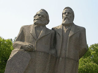 Close-up of large bronze statues of Marx and Engels.