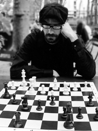 Photograph of a man playing chess.