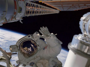 Astronaut Carlos I. Noriega, waves during the second of three STS-97 sessions of extravehicular activity. (NASA) 