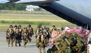 A photo of marines disembarking from a plane.