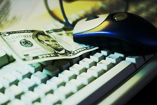 Photograph of a five dollar bill on a computer keyboard.